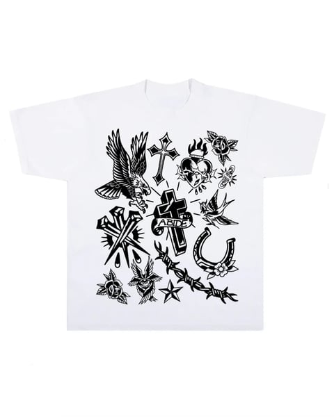 White t-shirt featuring black tattoo-style graphics including eagle, cross, roses, horseshoe, and stars